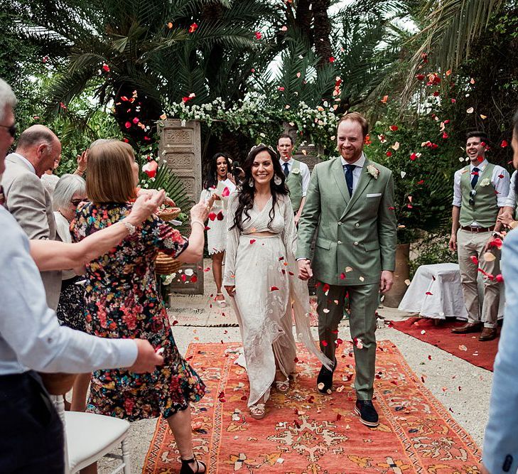 Outdoor Wedding Ceremony | Moroccan Rugs, Wooden Door Altar Wedding Decor | Bride in Rue de Seine Bridal Gown | Groom in Green Beggars Run Suit | Paradise Destination Wedding at Jnane Tamsna in Marrakech, Morocco | Nordica Photography | Matteo Castelluccia Film