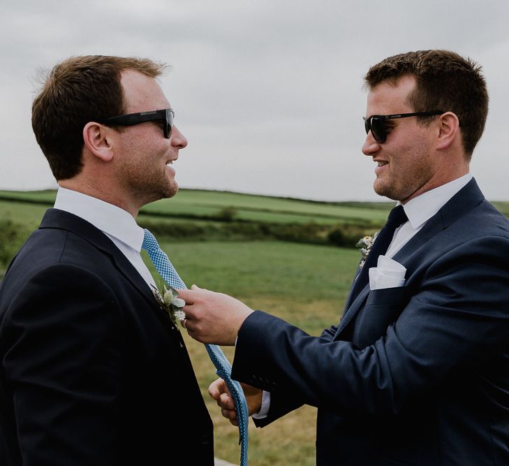 Groomsmen straightening the grooms tie