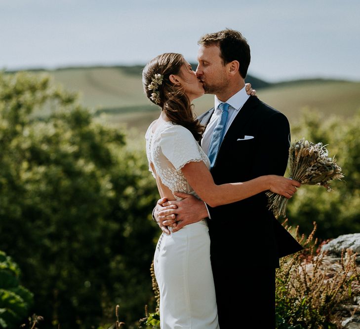 Bride with side ponytail and fresh flowers in her hair