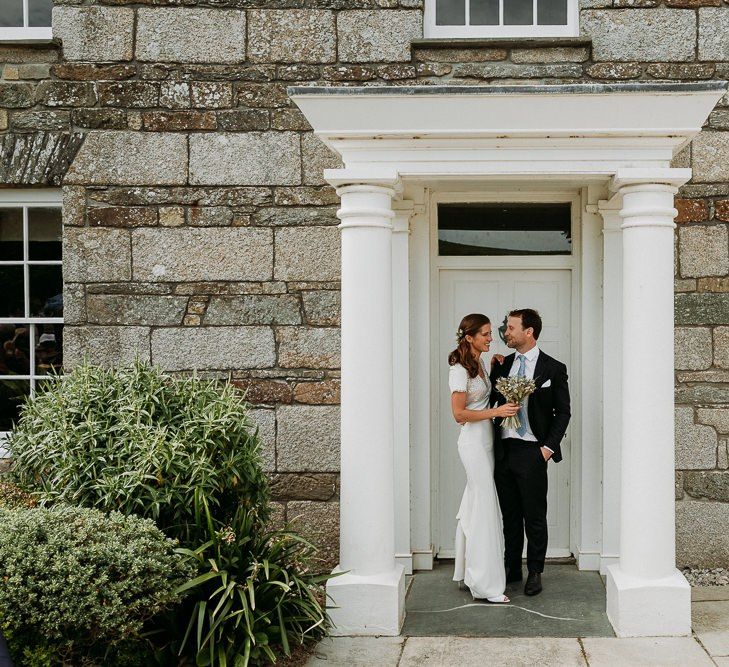 Bride and groom portrait in the doorway of Roscarrock Farm in Cornwall