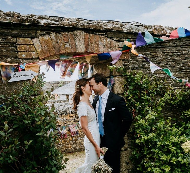 Bride and groom portrait next to their DIY wedding bunting