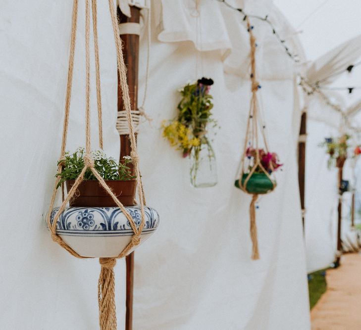 Hanging plant pots in macrame decorating the stretch tent reception