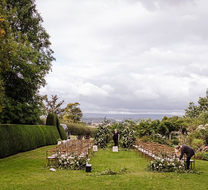 Outdoor autumn ceremony at Dewsall Court wedding with floral arch