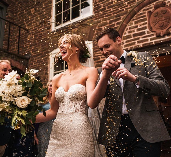 Bride and groom confetti shot at outdoor Dewsall Court wedding ceremony