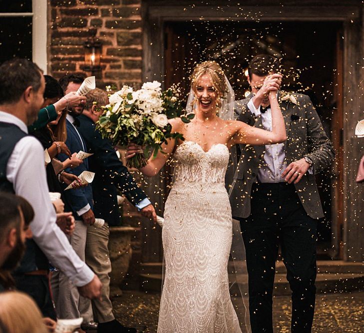 Bride and groom confetti shot at outdoor Dewsall Court wedding ceremony