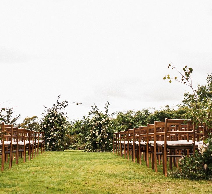 Outdoor autumn wedding ceremony at Dewsall Court wedding  with floral arch