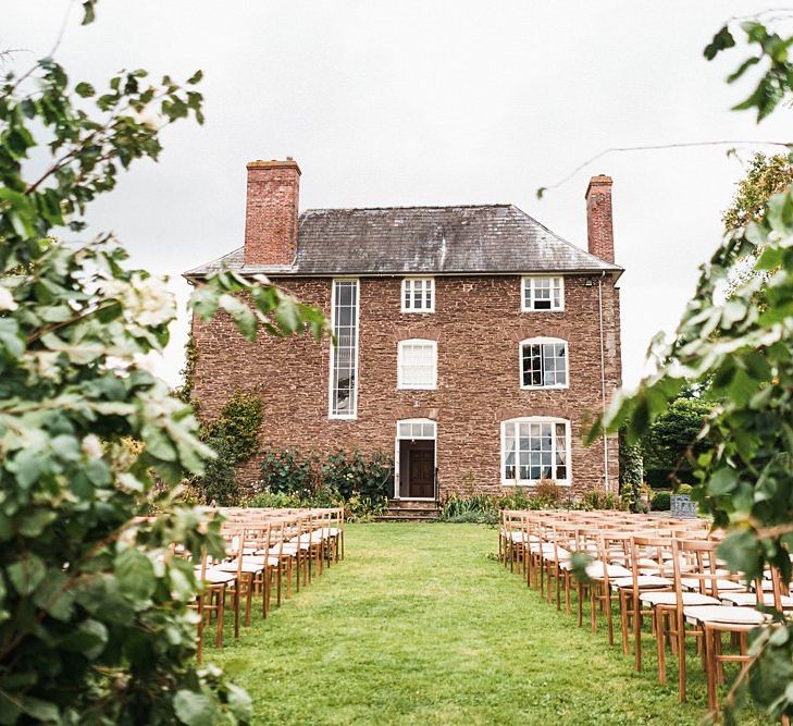 Outdoor autumn ceremony at Dewsall Court wedding with floral arch