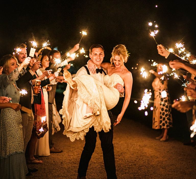 Guests provide a sparkler exit for bride and groom after barn reception