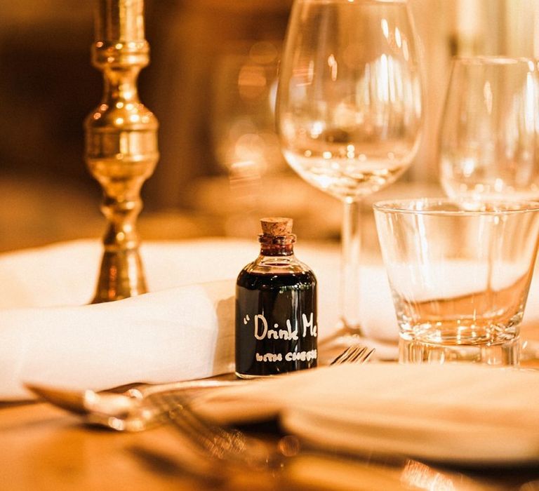 Table setting details with 'drink me' bottle for the speeches at Wainhouse barn reception