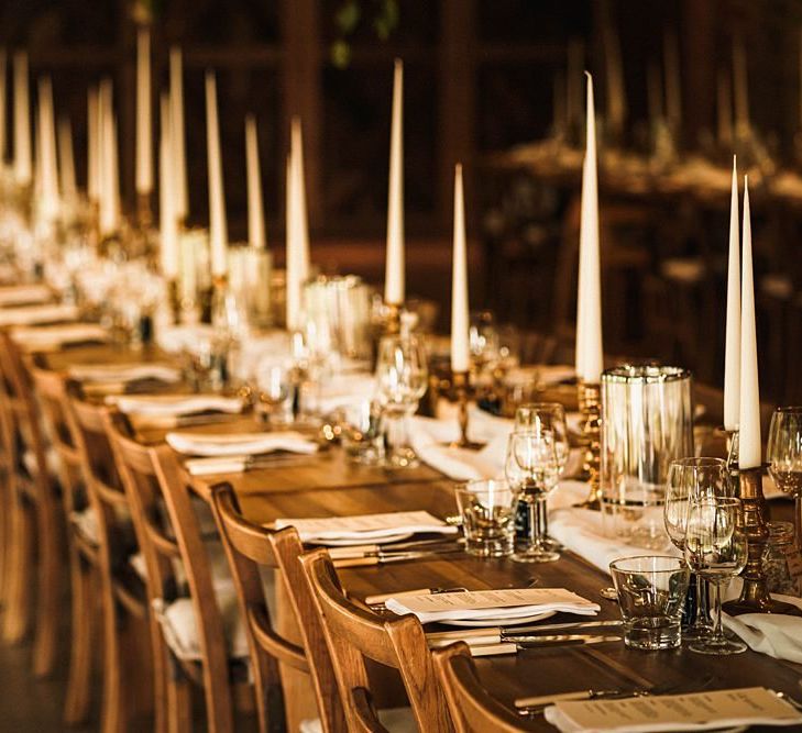 Reception venue details with sophisticated taper candles and relaxed fabric table runners