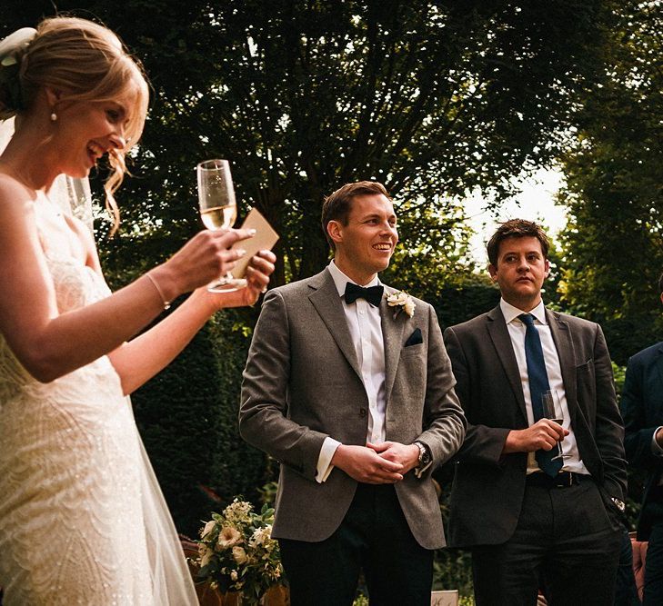 Bride shares a speech in strapless beaded dress with long veil