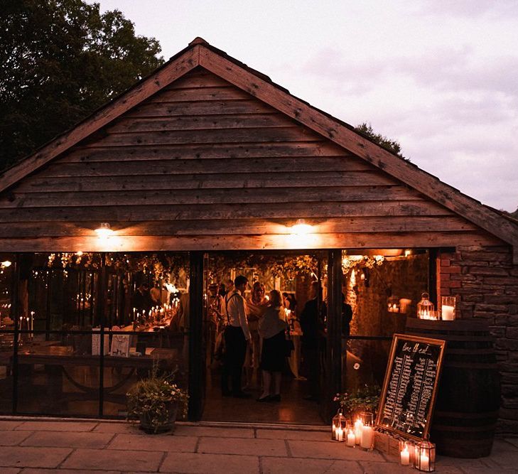 Reception details for autumn barn celebration with mirror table plan and candles