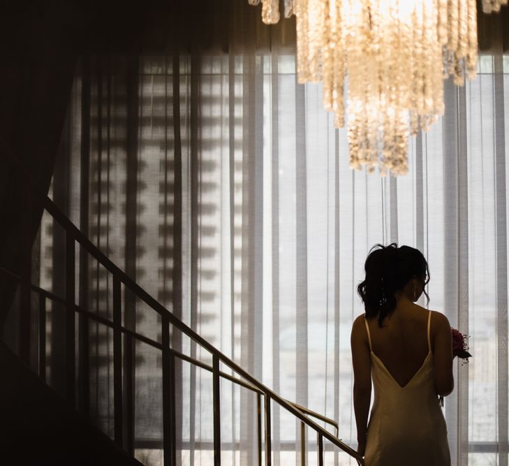 Bride in Silk BHLDN Dress with Spaghetti Straps and V-Back | Bridal Ponytail | Fuschia Sweet Pea Spray Silk Flowers Bouquet | Las Vegas Wedding with Gold Sequin Bridesmaids Dresses and Silk Flowers | Chris Barber Photography