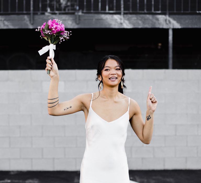 Bride in Silk BHLDN Dress with Spaghetti Straps and V-Back | Bridal Ponytail | Fuschia Sweet Pea Spray Silk Flowers Bouquet | Las Vegas Wedding with Gold Sequin Bridesmaids Dresses and Silk Flowers | Chris Barber Photography