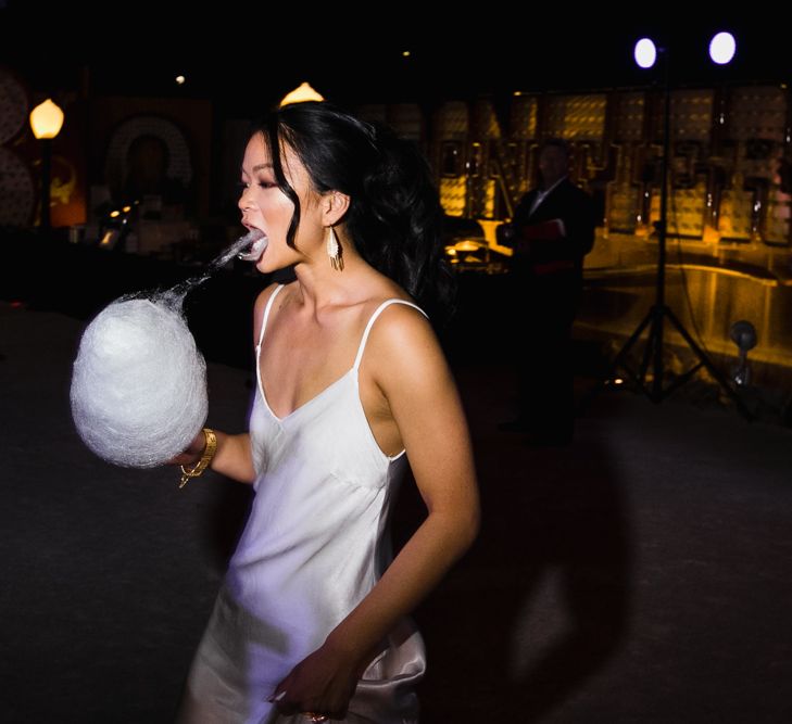 Bride in Silk BHLDN Dress with Spaghetti Straps and V-Back | Bridal Ponytail | Cotton Candy Machine | The Neon Museum | Las Vegas Wedding with Gold Sequin Bridesmaids Dresses and Silk Flowers | Chris Barber Photography