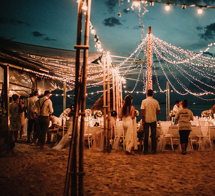 Outdoor Reception | Fairy Light Canopy | Bride in Grace Loves Lace Gia Wedding Dress | Groomsmen in Turned Up Trousers, Bow Ties &amp; Braces from Topman | Tropical Destination on the Beach at Nice Sea Resort, Koh Phangan Thailand Planned by Phangan Weddings | Carla Blain Photography