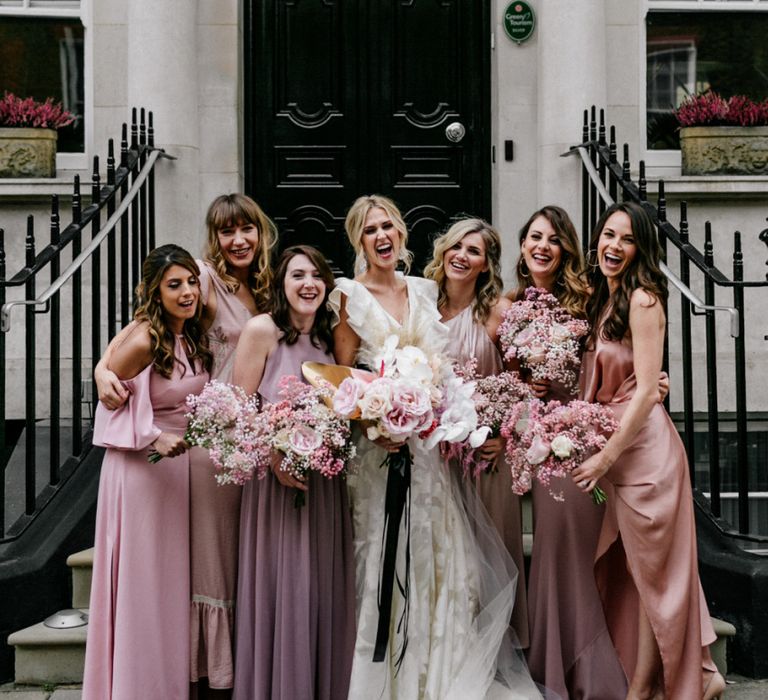 Stylish Bridal Party Portrait in Pink Bridesmaid Dresses and Ruffle Wedding Dress