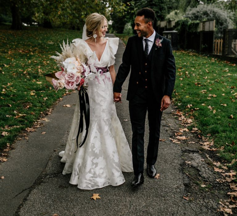 Stylish Bride and Groom Portrait by Epic Love Story with Ruffle Wedding Dress and Navy Suit