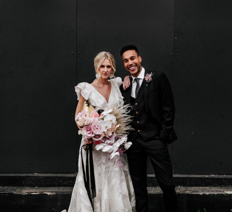 Stylish Bride and Groom in Ruffle Wedding Dress and Navy Suit