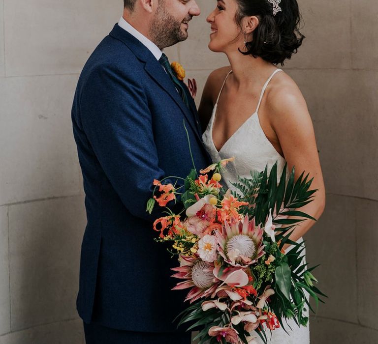 Bride Holds Orange Wedding Flowers With Embellished Hair Accessory