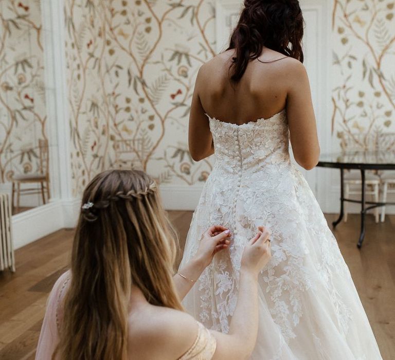 Bride in white strapless bride dress before outfit change into Indian wedding dress