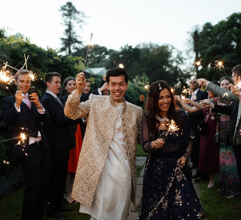 Sparkler exit for groom and bride in traditional Indian wedding dress