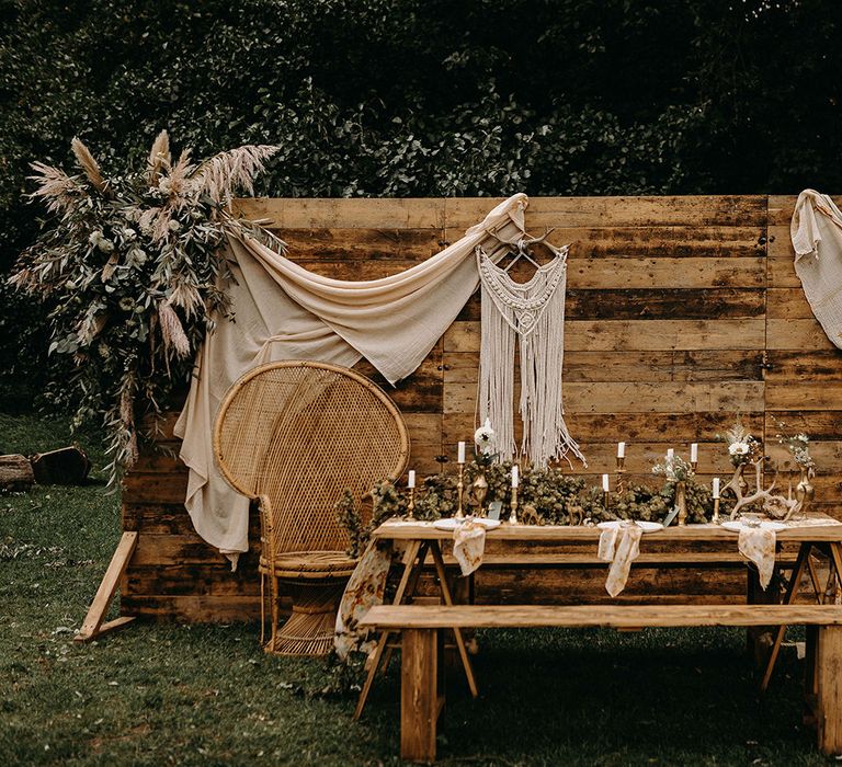 Wooden Backdrop with Drapes, Dried Flowers &amp; Macrame Decor | Wooden Table with Candle Sticks &amp; Greenery Garland | Nude Bohemian Wedding Inspiration by Wonderland Invites &amp; Rock The Day Styling | Kelsie Low Photography