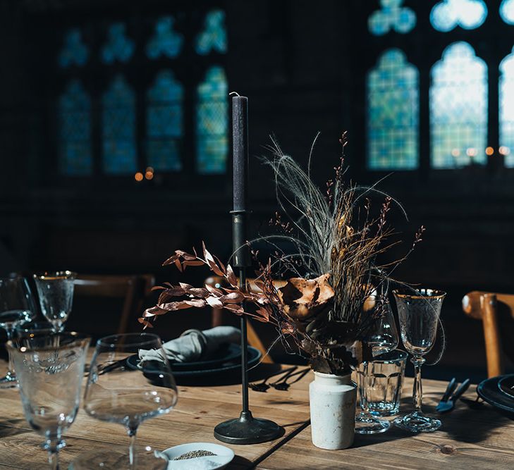 Long tables styled with dark and earthy tones mixed with metallic touches at St Stephens Trust wedding reception with balloon installation