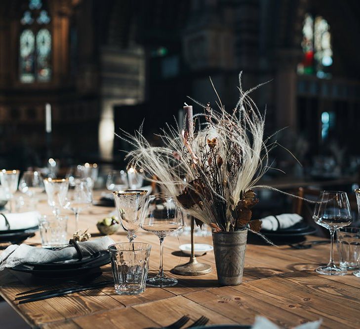 Long tables styled with dark and earthy tones mixed with metallic touches at St Stephens Trust wedding reception with dried flower arrangements