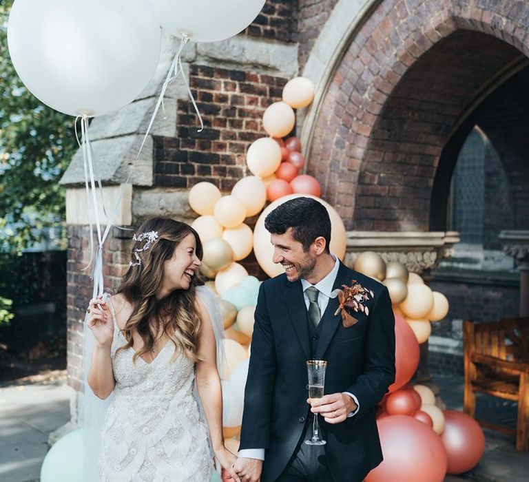 Bride and groom tie the knot at relaxed autumn wedding with dried floral decor and balloon installation