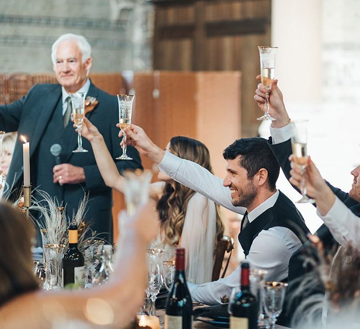 Bride and groom raise a glass at their St Stephens Trust reception with relaxed styling and dried floral decor