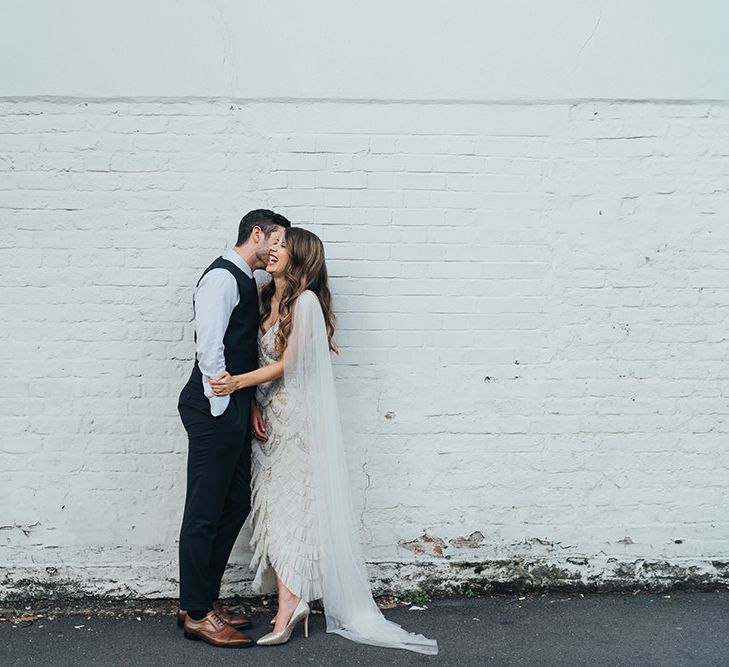 Bride and groom embrace at relaxed autumn celebration with balloon installation