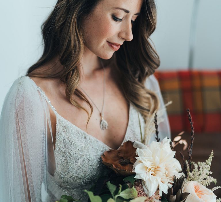 Bride wearing an embellished hair accessory with a peach bouquet using fresh and dried flowers