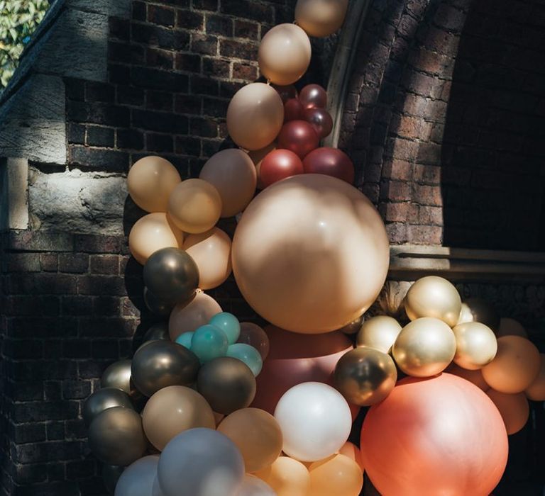 Balloon installation for relaxed autumn celebration at St Stephens Trust with peach wedding theme