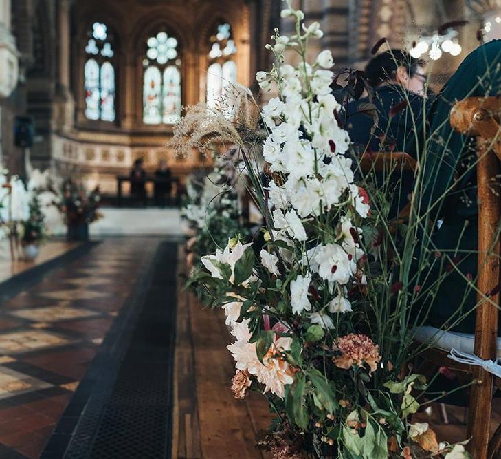 Church ceremony with balloon installation and fresh aisle decor of seasonal foliage and cafe au lait dahlias