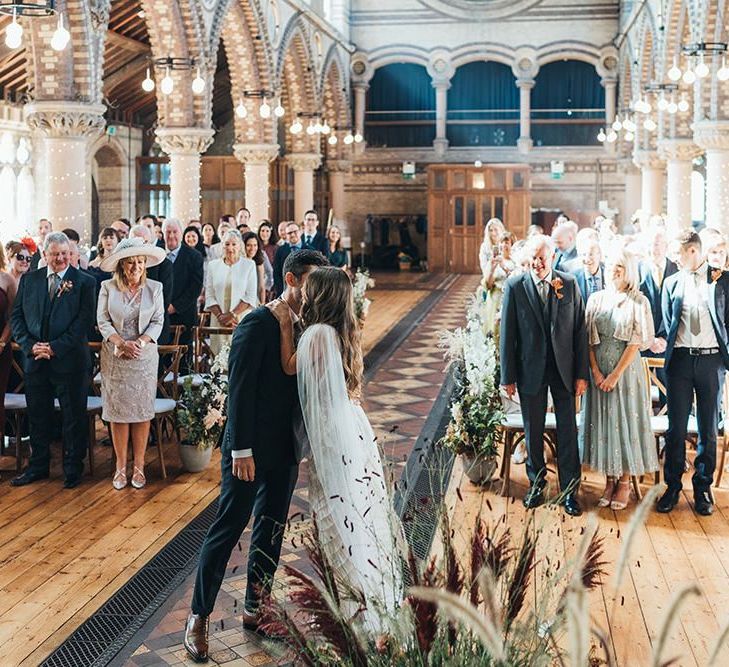 Bride and groom embrace at church ceremony with dried flower decor and balloon installation