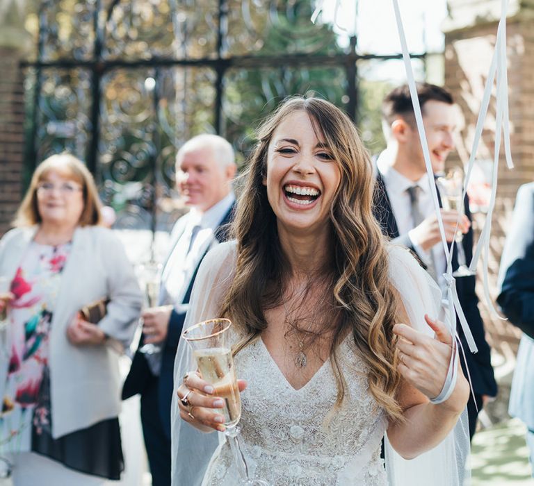 Bride wearing embellished custom made dress with watteau train and balloon installation