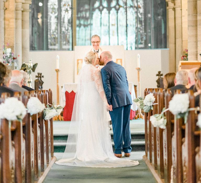 Bride and Groom Kissing at the Altar