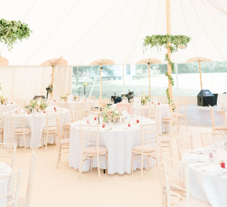 PapaKata Sperry Tent Reception with Greenery Wrapped around The Poles and Hanging Chandeliers