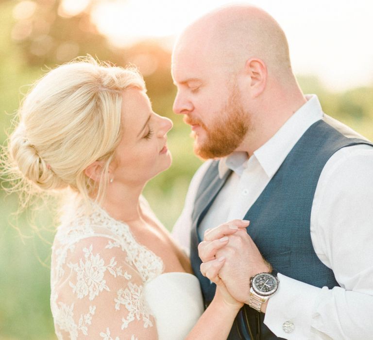 Bride in Suzanne Neville Wedding Dress and Lace Bolero and Groom in Navy Hugo Boss Waistcoat and Trousers Embracing