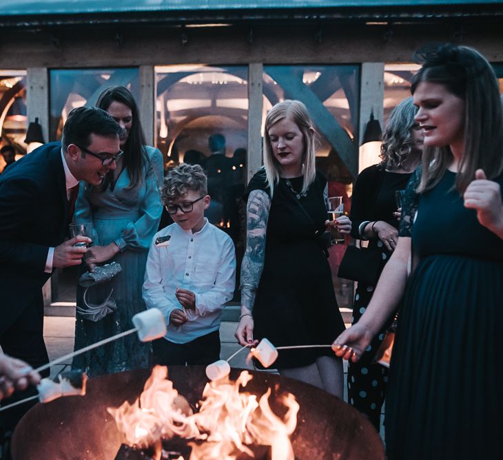 Marshmallows by the fire | Blush Pink and Copper | RMW The List Members Hazel Gap Barn, Nottinghamshire | Mikaella Bridal Gown | Pear and Bear Photography