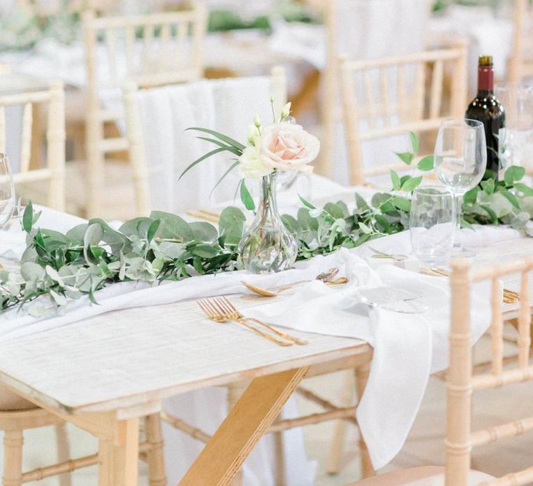 Wedding table decor with blush flowers and foliage table runner