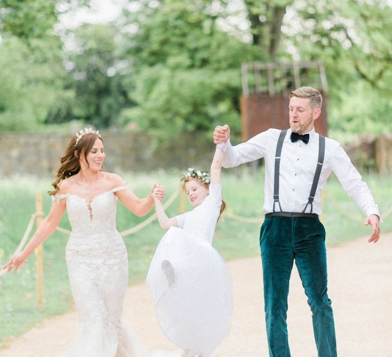 Bride in detachable skirt wedding dress with groom and flower girl