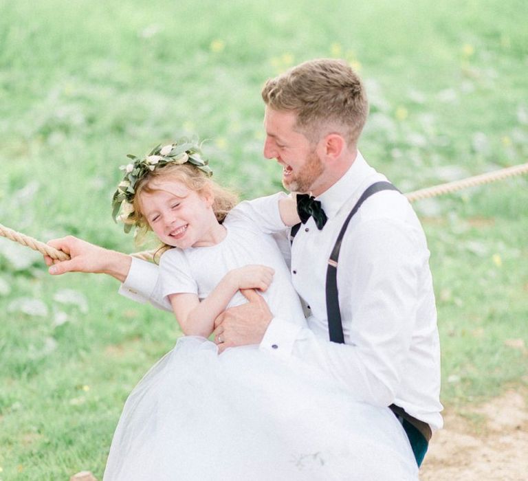 Groom and flower girl in white dress with flower crown