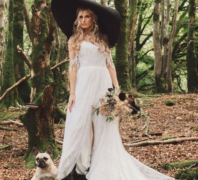 Boho Bride in Cold Shoulder Wedding Dress with Tassels and Giant Black Hat