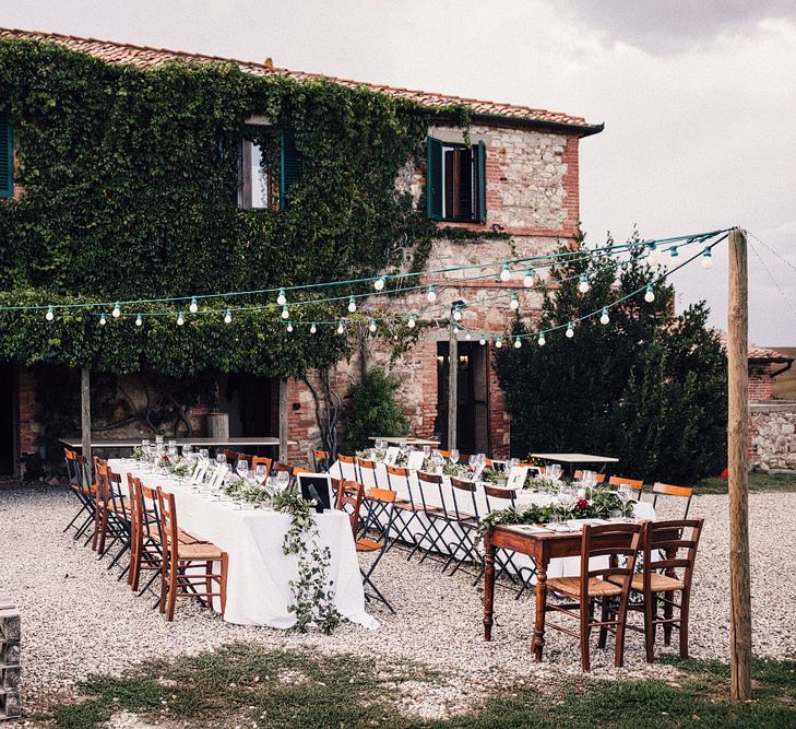 Long Banquet Tables | Sweetheart Table | Foliage Table Runners | Festoon Lights | Outdoor Wedding Reception at Il Rigo Agriturismo, Tuscany | Rue de Seine Wedding Dress with Pronovias Overskirt, Personalised Place Setting Illustrations and Sweetheart Table | Samuel Docker Photography