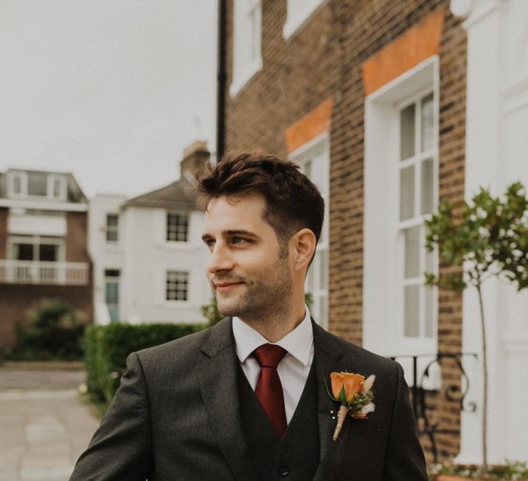 Groom wearing three piece suit and rose buttonhole at intimate wedding in London