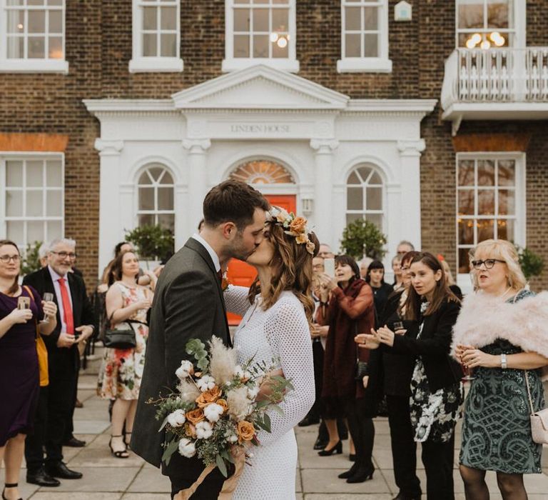 Bride and groom embrace at Linden House ceremony with closest friends and family