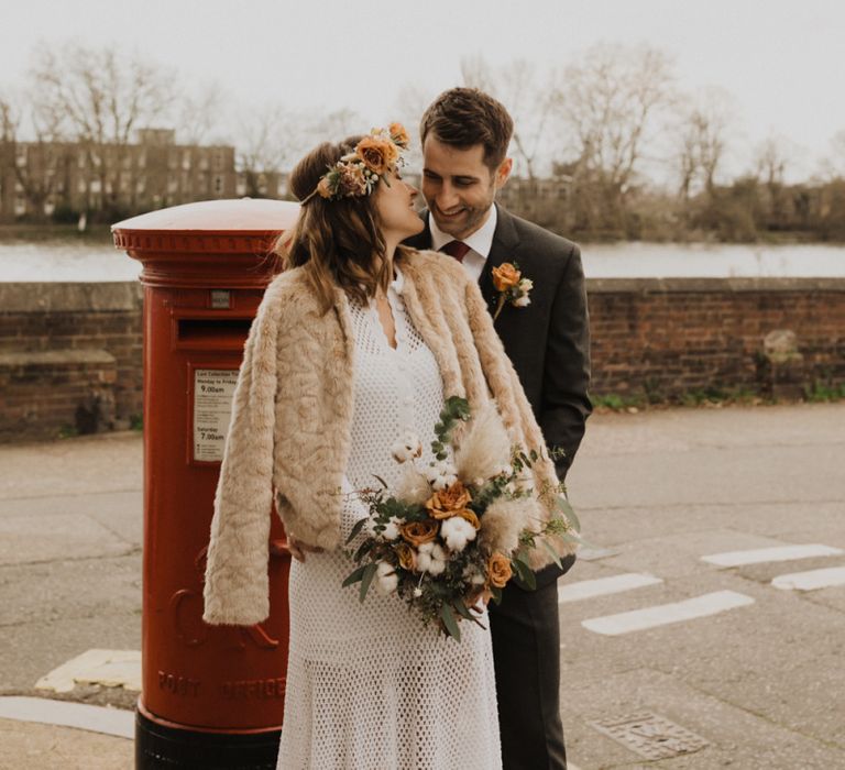 Bride and Groom steal a moment at London wedding wearing vintage dress and flower crown