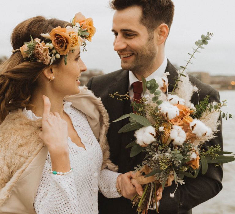 Rose and cotton flower details at London wedding with floral crown and faux fur bomber